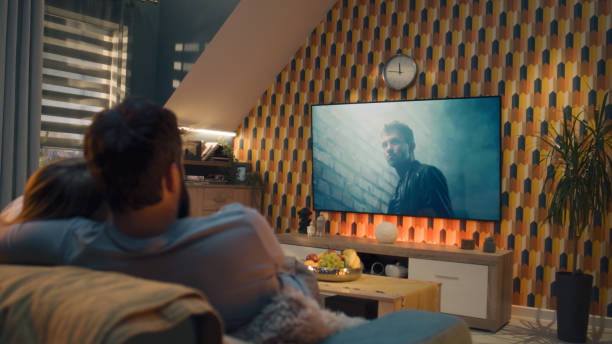 istock Couple on sofa watching action movie 1433320282