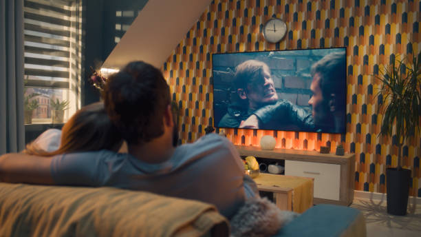 istock Couple on sofa watching action movie 1433324382