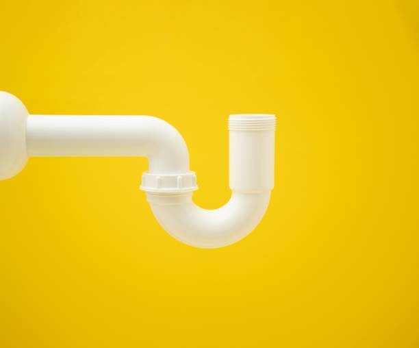 istock Closeup of a white siphon pipe on a vibrant yellow background with copy space 1433325538