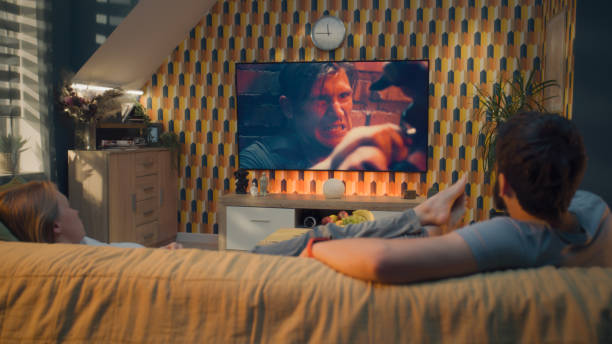 istock Couple on sofa watching action movie 1433325618