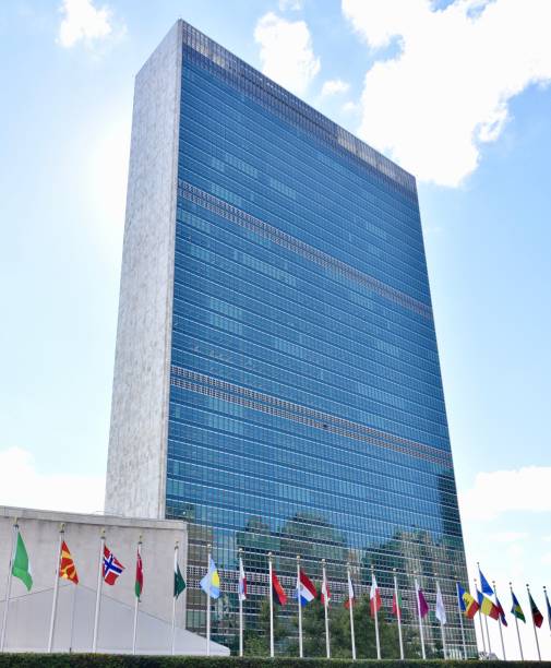 istock Vertical low angle shot of a modern building with flags at the bottom on a sunny day 1433325643