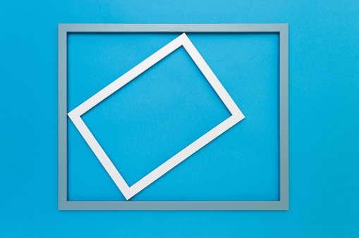 A White frame rotated in a light blue frame on a vibrant blue background