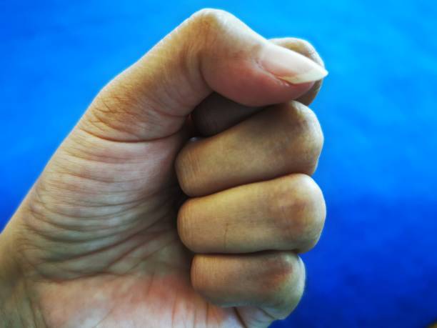 istock hands clenched or fist against blue background 1433330950