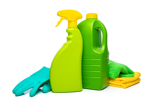 Cleaning concepts: Green and yellow household cleaning products and tools isolated on white background. The composition includes a spray bottle, disinfectant bottle, washing up gloves and rag. Copy space High resolution 42Mp indoors digital capture taken with SONY A7rII and Zeiss Batis 40mm F2.0 CF lens