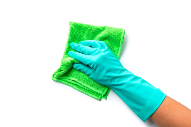 Cleaning concepts: Human hand wearing washing up glove holding a green microiber towel isolated on white background. Copy space High resolution 42Mp indoors digital capture taken with SONY A7rII and Zeiss Batis 40mm F2.0 CF lens