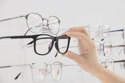 Hand with eyeglass in optical shop, holding eyeglasses