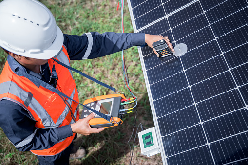 Engineers are checking the solar panels with a performance checker to verify that each solar panel is working at full efficiency. Alternative energy to conserve the world's energy. renewable business.