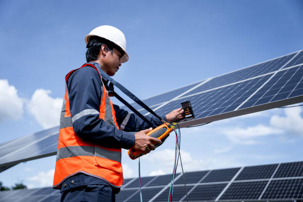 Engineers are checking the solar panels with a performance checker to verify that each solar panel is working at full efficiency. Alternative energy to conserve the world's energy. renewable business stock photo