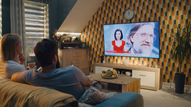 istock Couple watching smartphone presentation on TV 1433335964