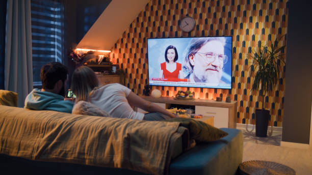 istock Couple watching phone exhibition on TV 1433343104