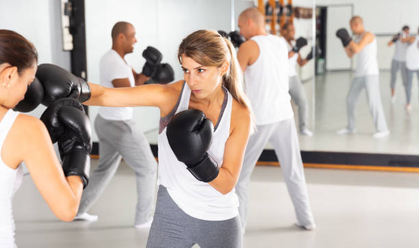 istock Concentrated woman practicing boxing punches in sparring 1433344940