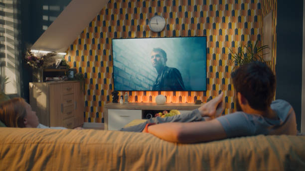istock Couple on sofa watching action movie 1433347747