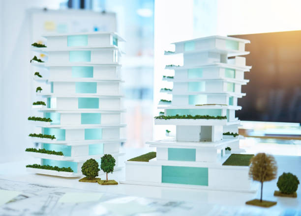 istock Building real estate model on a table in an architecture or construction business office. Creative 3d apartment or hotel design on a planning desk with blueprint paper in real estate agent company desk 1433347844