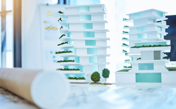 istock Architecture, design and 3D building of a creative plan for construction with blueprints on a table in an office. Business plans of architectural work for development out on a desk in the workplace. 1433348510