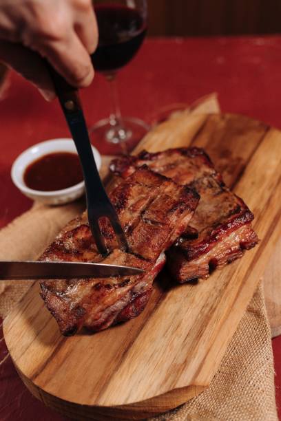 istock Cooked steak being cut on a wooden board by a meat fork and a knife 1433352510