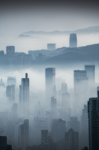 An aerial view of cityscape Hong Kong surrounded by buildings in foggy day