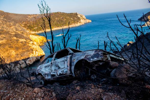 An old car left on a hill near the sea