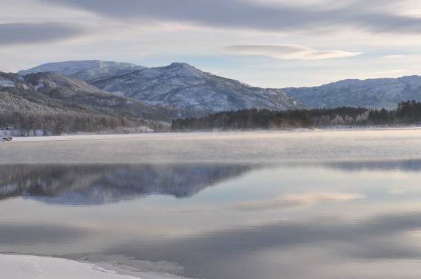 istock River view at sunset with water reflecting snowy mountains and a purple, cloudy sky 1433354677