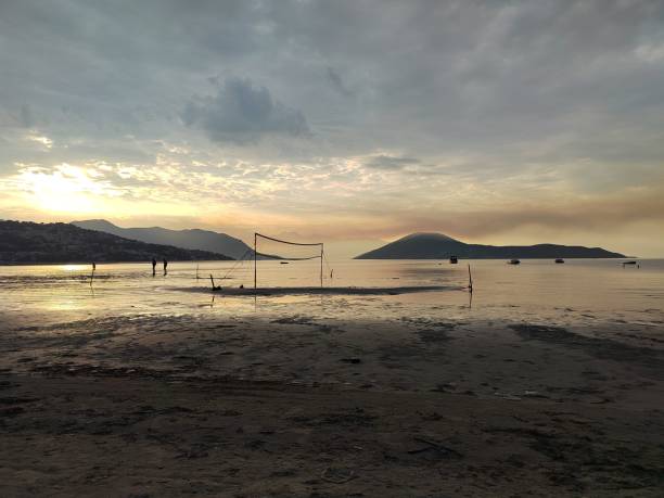 istock Muddy beach with footsteps at sunset cloudy sky 1433355373