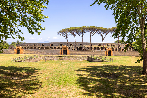 Pompeii, Naples, Italy - June 26, 2021: View on Amphitheatre of Pompeii buried by the eruption of Vesuvius volcano in 79 AD. It is the oldest surviving Roman amphitheatre
