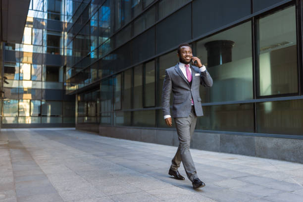 istock Black businessman texting in front of the office building 1433356253