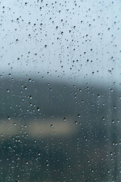 Raindrops on a window on a rainy day - rain concept, textures and patterns Raindrops on a window on a rainy day - rain concept, textures and patterns lluvia stock pictures, royalty-free photos & images