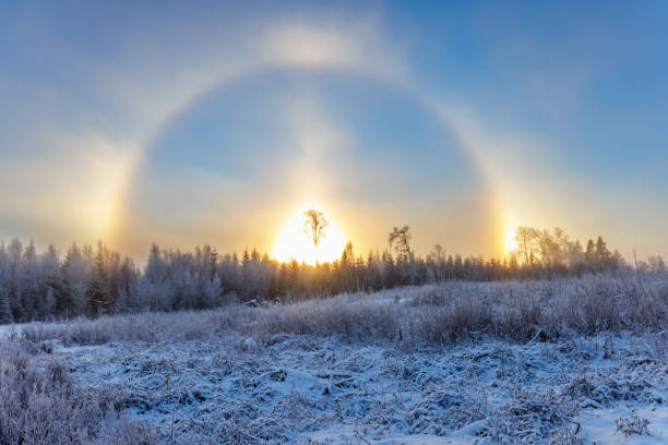 Halo with sun dogs in a winter landscape Halo with sun dogs in a winter landscape sundog stock pictures, royalty-free photos & images