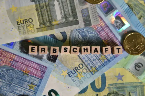 the german word for inheritance with wooden cubes and euro bills
