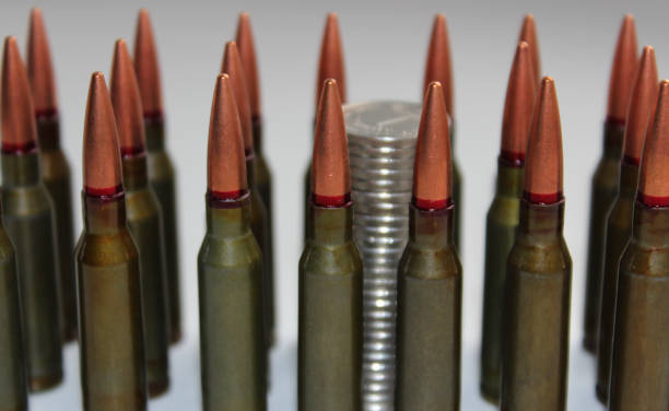 istock Detailed side view coins column through a group of unitary cartridges lined up on a white background 1433365586