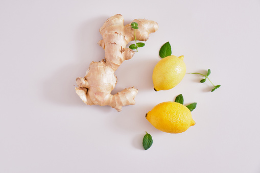ginger root, mint leaves and lemons on a gray background, health benefits of ginger, natural drink for immunity copy space