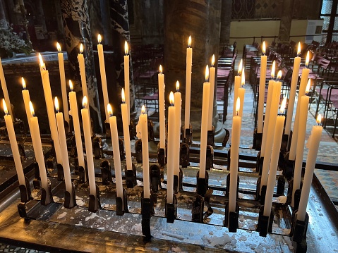 Several candles burning in a church.