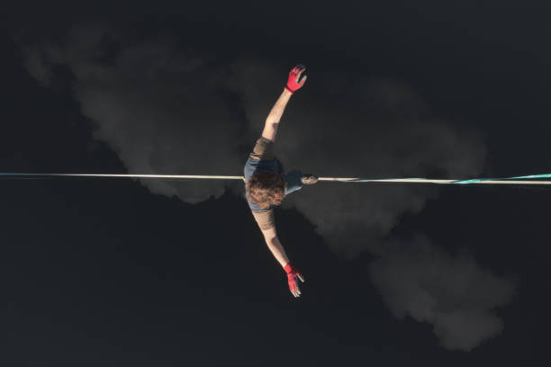 Highline over water. The athlete walks on a line above the water. Epic aerial view. The highliner walks on a line above the water. Top view. Clouds are reflected in the water. Active lifestyle highlining stock pictures, royalty-free photos & images