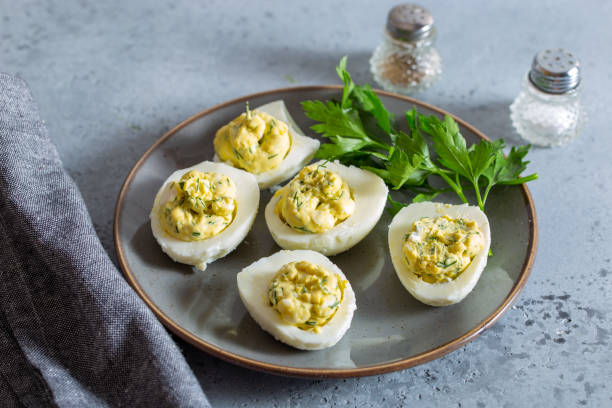 istock Step-by-step preparation of an egg snack with red fish with a carrot decoration, step 4 - placing the filling in the halves of the eggs, selective focus 1433379038