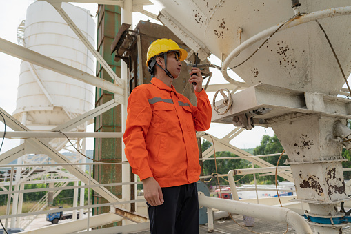 On the concrete mixer, the worker uses the walkie-talkie to report the situation