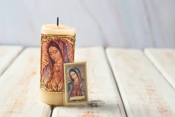 Candleholder and holy card with the image of the virgin of guadalupe of mexico.