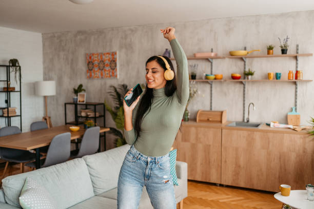 istock Young Woman Singing And Dancing At Home 1433385069