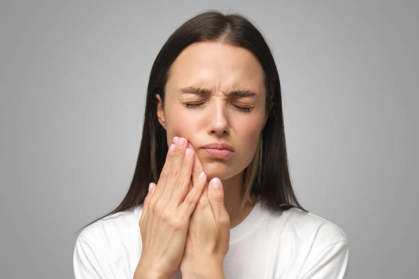 istock Miserable woman experiencing severe toothache, pressing palm to cheek, closing eyes because of pain 1433385516