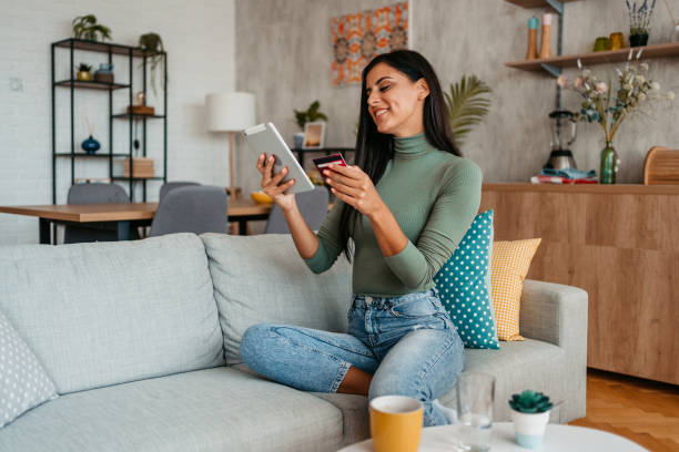 istock Young Woman Shopping Online Using Tablet At Home 1433385615