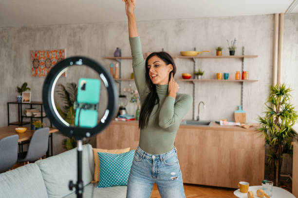 istock Young Woman Filming Herself Dancing At Home 1433385943