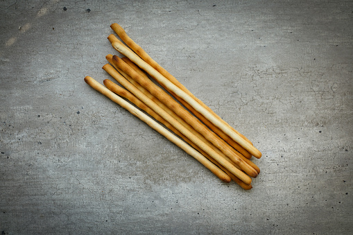 Italian Grissini on a concrete background. Grissini is a particular kind of bread made in the note of Italy.