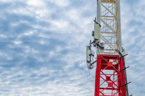 istock Red and white communication tower. Tower with mobile communication antennas in the countryside. 1433387319