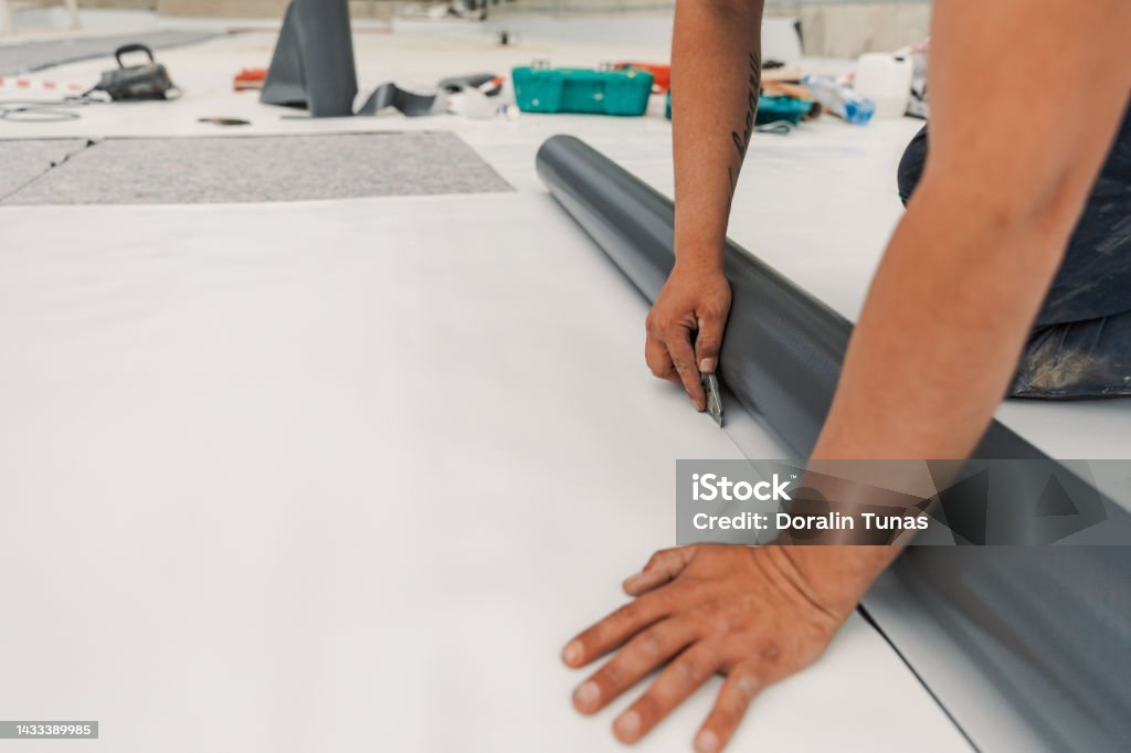 Worker specialized in mounting PVC membranes, TPO in the process of installing a water resistant system Worker specialized in mounting PVC membranes, TPO in the process of installing a water resistant Rooftop Stock Photo
