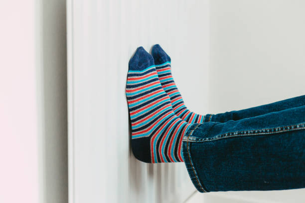 istock Warming his feet on the radiator wearing stripy socks 1433391240