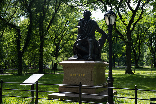 People walk past the statue of George Washington (by Thomas Ball, 1869) in the Boston Public Garden in downtown Boston, Massachusetts, USA on a cloudy day.