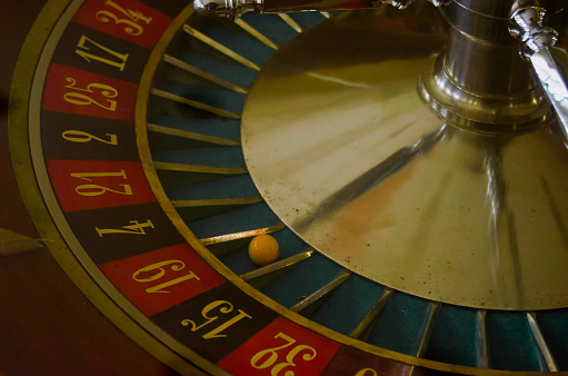 Antique casino roulette with the ball on the red 19