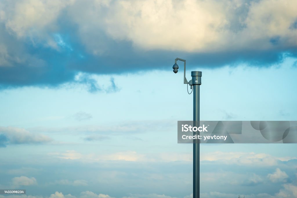 Sunny day view of UK motorway traffic with CCTV camera on foreground Sunny day view of UK motorway traffic with CCTV camera on foreground. Security Camera Stock Photo