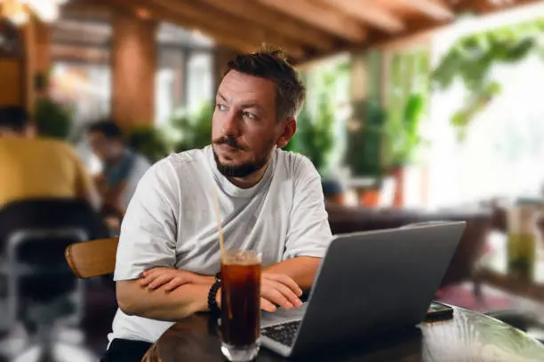 Portrait of man using his laptop while sitting in a cafe
