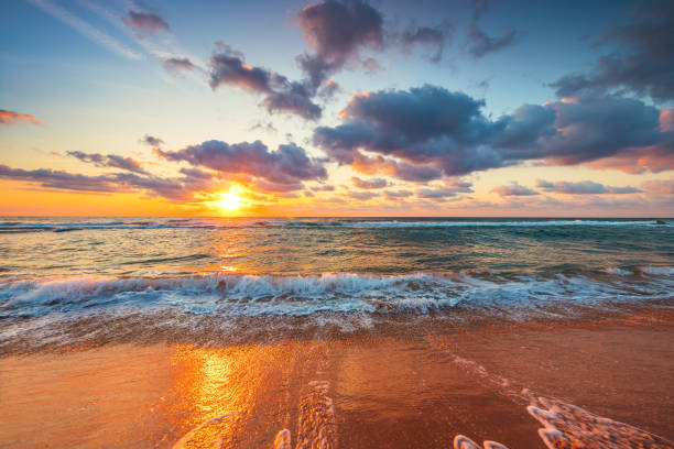 Beautiful sunrise over the sea waves and beach on tropical island beach stock photo