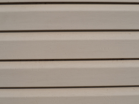 Abstract background texture. Beige Vinyl Siding Exterior Plastic Wall Panel. Element of the facade decoration close-up