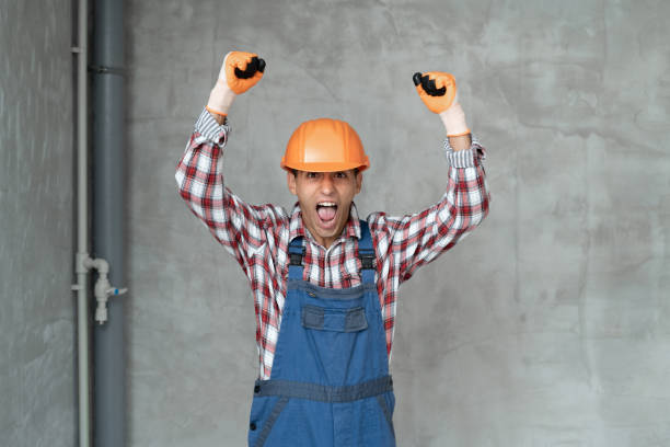 istock Angry builder man wearing construction uniform and safety helmet over gray wall background shouting and screaming with hands up. Communication and profession 1433405132